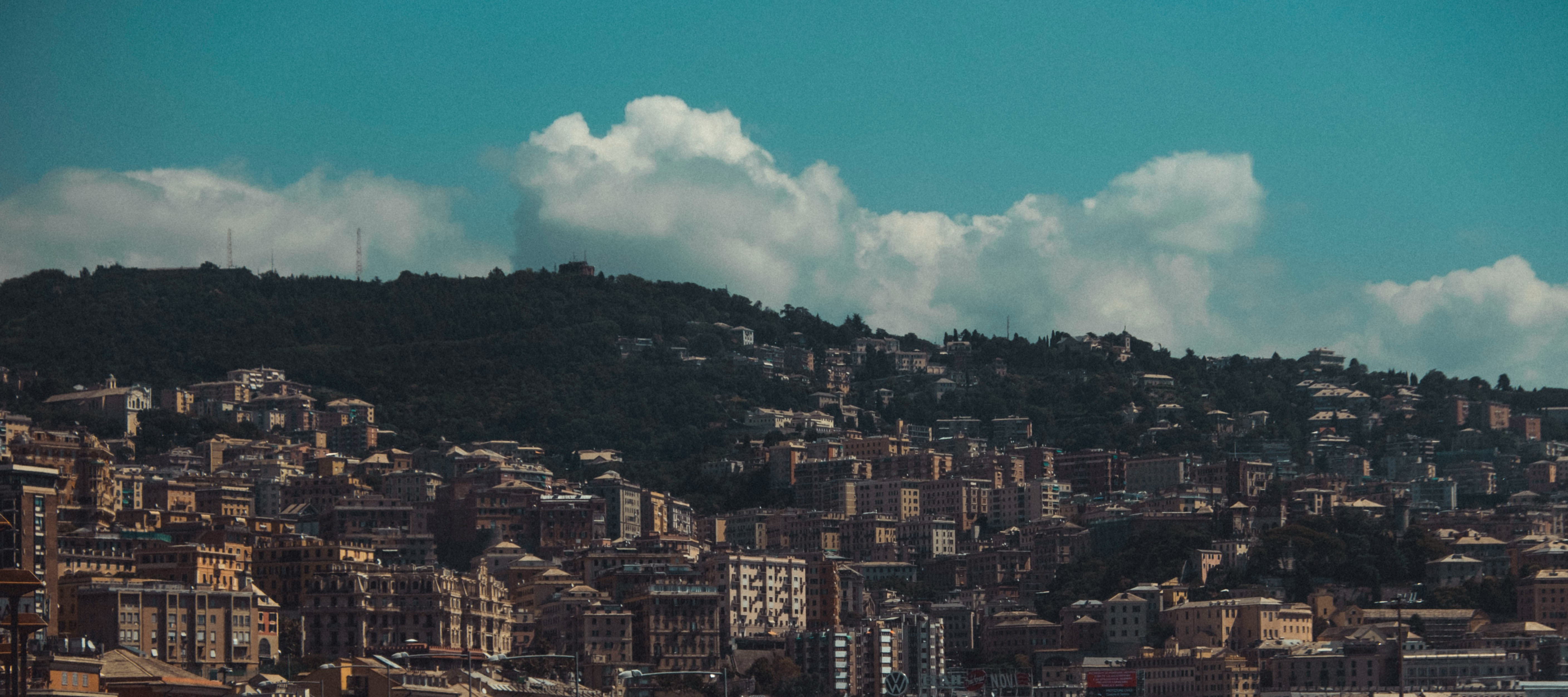 city buildings under blue sky and white clouds during daytime